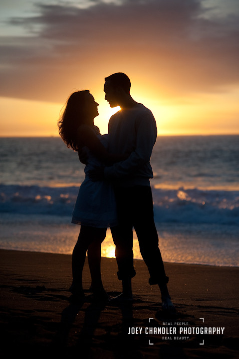 Young couple Silhouetted against the sunset at Baker Beach in San Francisco