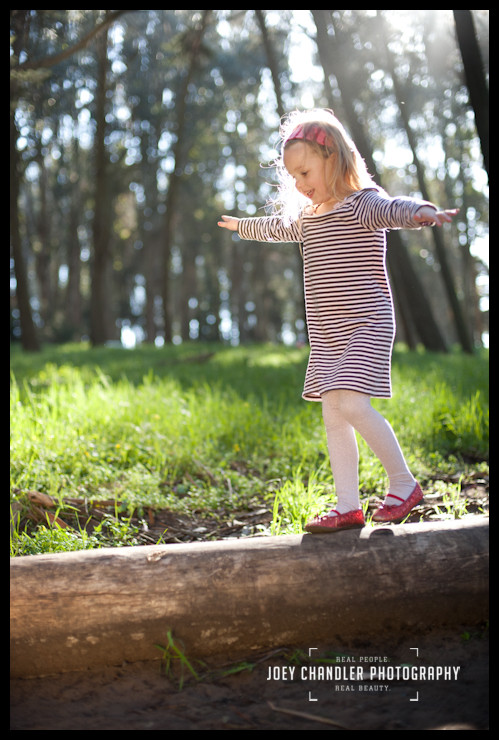 No place like the Presidio to wear fabulous red shoes young girl wearing read shoes balancing on a log in San Francisco's Presidio