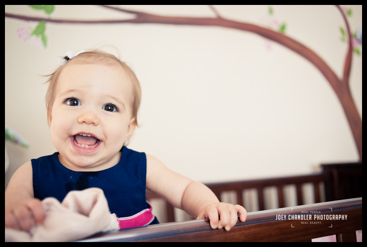 Girl smiling in her crib for family photographs Girl smiling in her crib for family photographs
