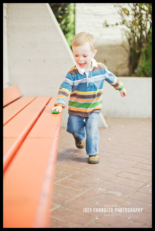 Smiles at the Muni Station for family portraits Blonde boy running with toy car at San Francisco Muni Station