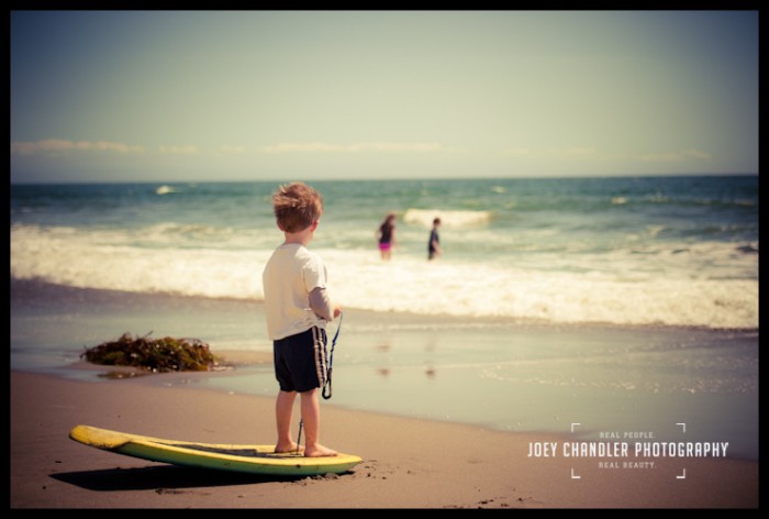 Lucius standing on a boggie board at the beach in Capitola Boy standing on boggie board at the beach in Capitola