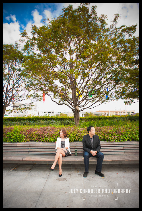 Have a moment during a date in San Francisco With a big tree behind them, a couple sits on a park bench slightly apart, not looking at each other.