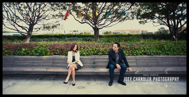 Sneaking a peak on a San Francisco Date Sitting on a park bench, a woman looks over at the man sitting beside her- he seems not to be responding.