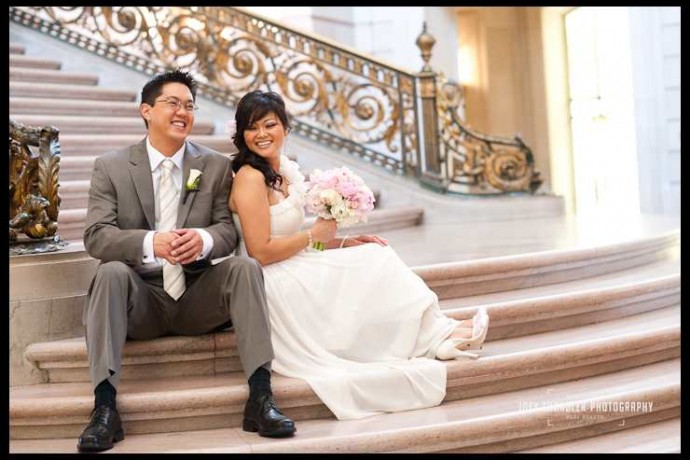 Bride and groom sitting in rotunda at San Francisco City Hall