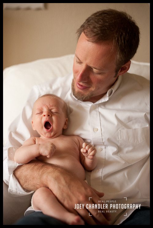 Baby yawning with dad. Father looks on as his newborn baby yawns.