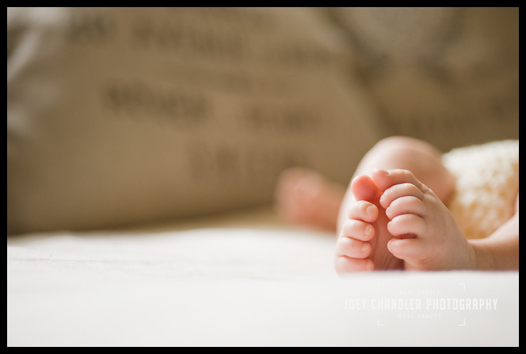 The feet of a San Francisco Baby Focus on the two small feet of a newborn baby curled together on a soft surface fading into the background