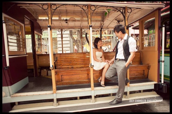 An engaged couple sitting in a San Francisco Cable Car