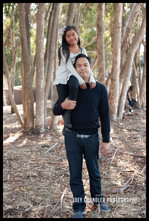 Little girl on dad's shoulders in the woods at Perry Farms
